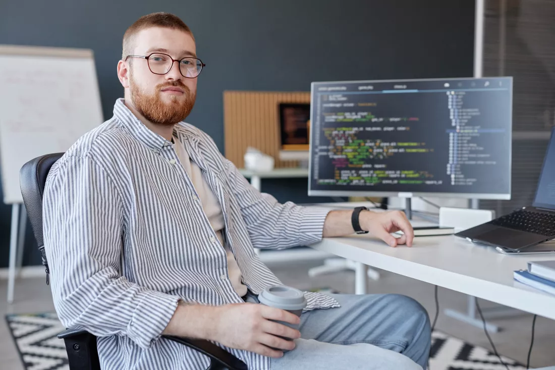 portrait-man-sitting-office-holding-coffee