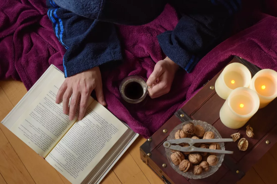 high-angle-view-hand-holding-coffee-cup-while-reading-book-table