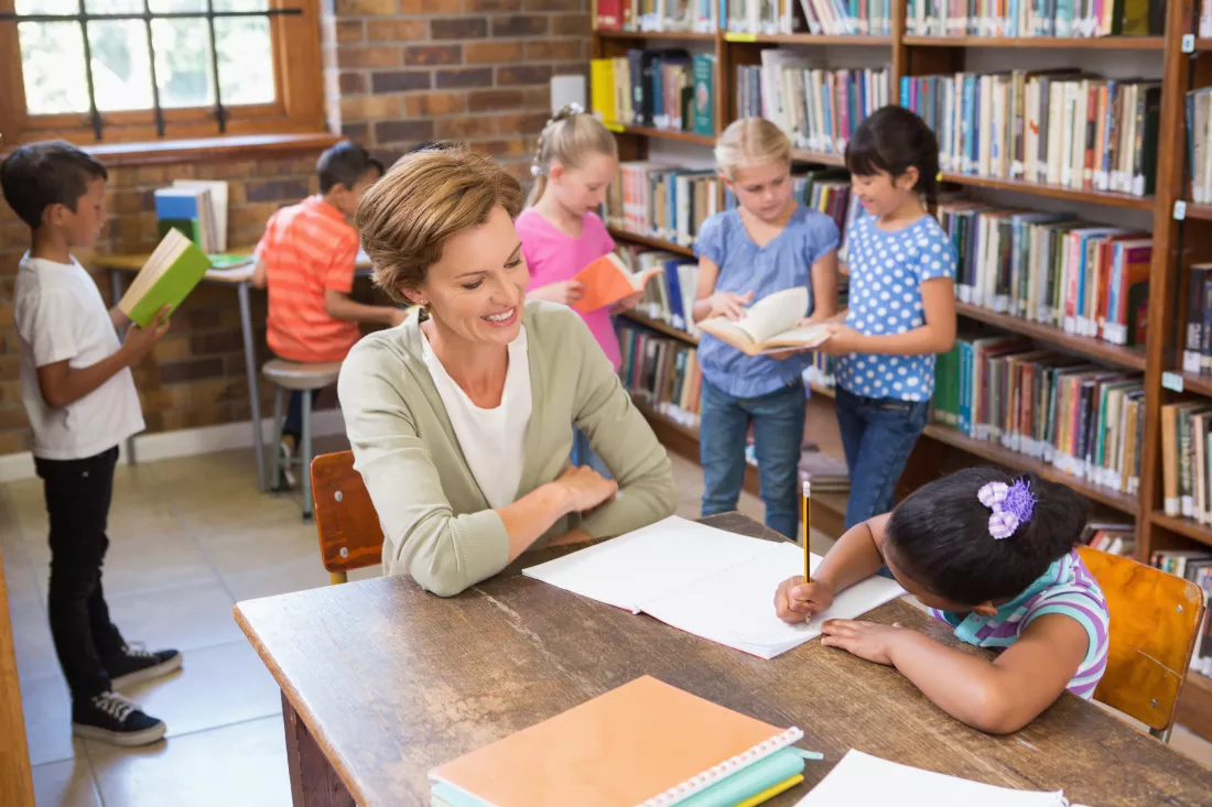 teacher-helping-pupil-library