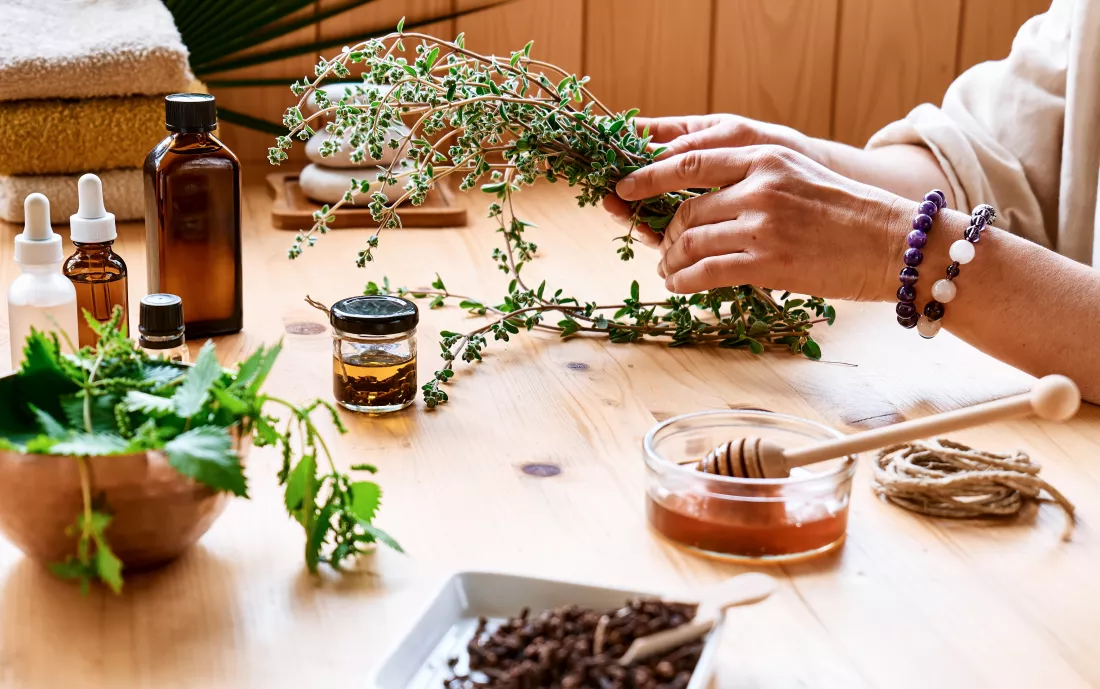 woman-prepares-aromatherapy-session-table-with-essential-oil-medical-herbs