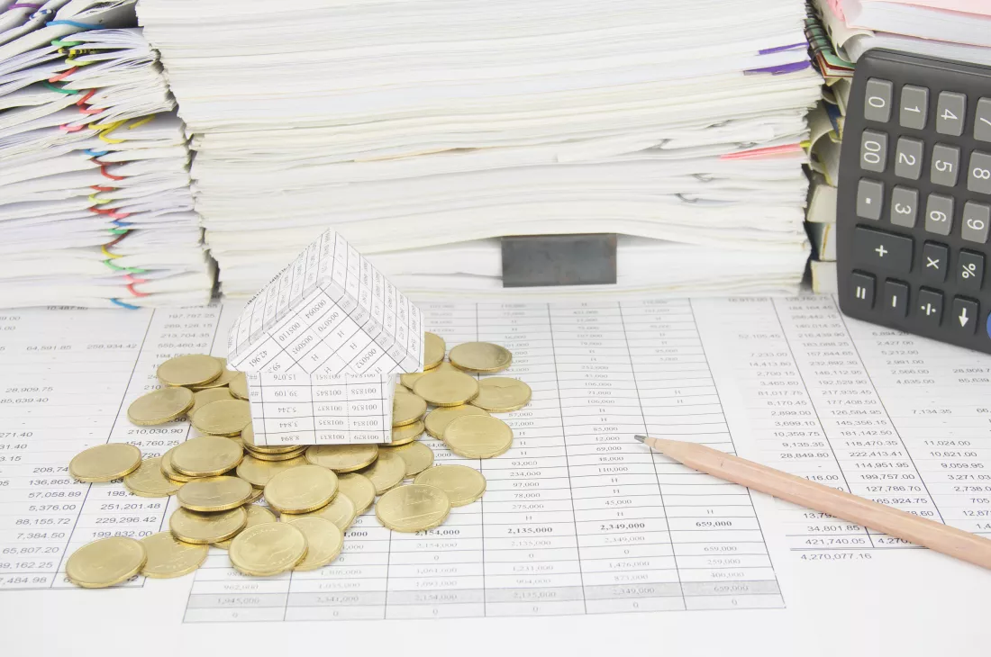 high-angle-view-coins-with-model-house-calculator-financial-documents