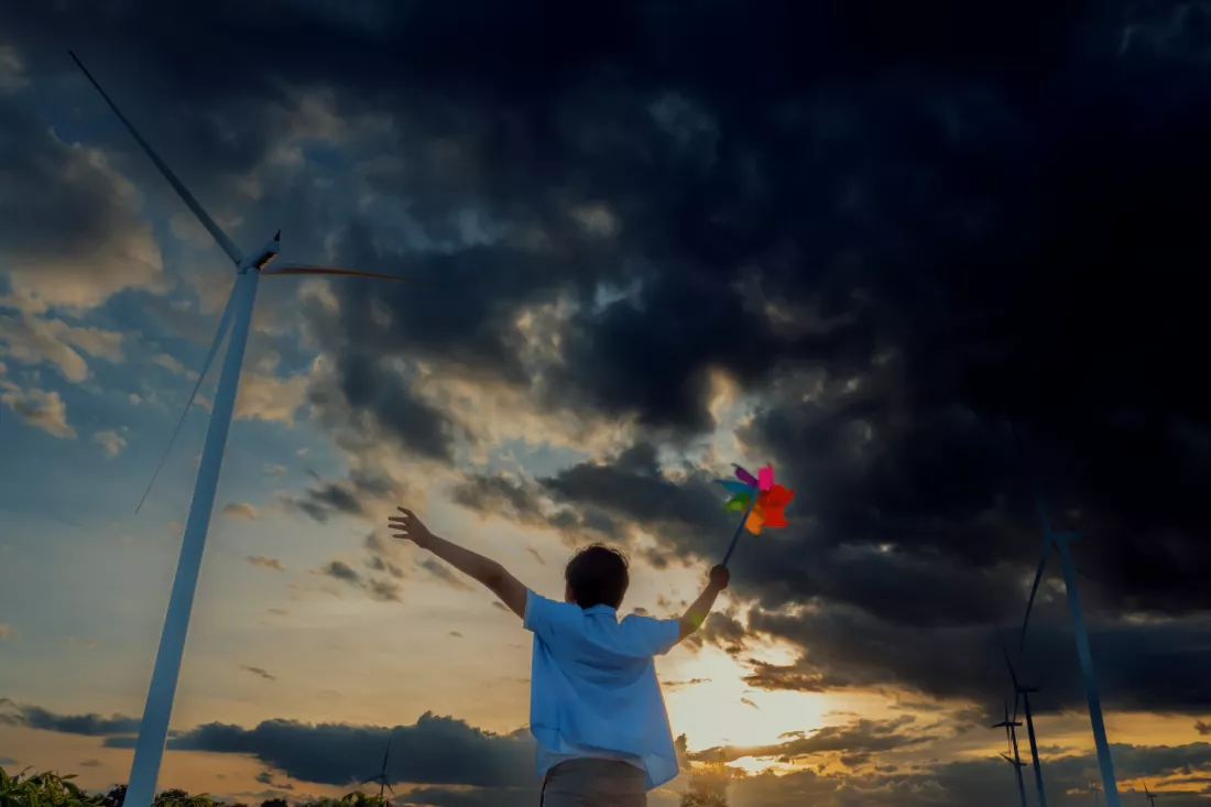 progressive-young-asian-boy-playing-with-wind-pinwheel-toy-wind-turbine-farm