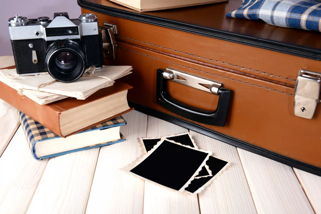 vintage-suitcase-with-clothes-books-table-dark-background